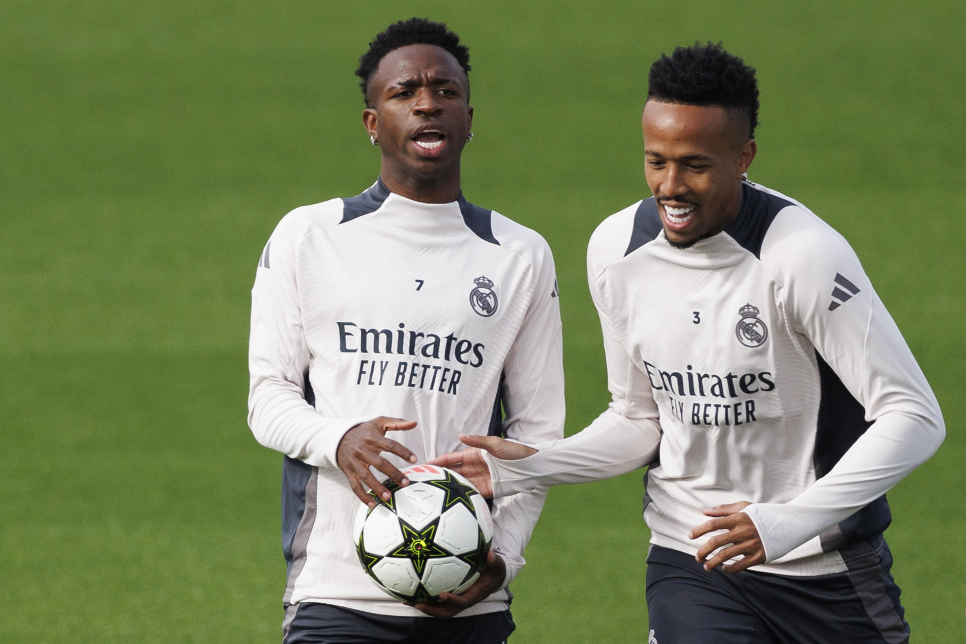 Los jugadores brasileños del Real Madrid, Vinicius Junior (i) y Eder Militao, durante el entrenamiento del equipo en la Ciudad Deportiva de Valdebebas, este lunes, para preparar el partido de la cuarta jornada de la Liga de Campeones que mañana disputarán frente al AC Milan en el estadio Santiago Bernabéu de Madrid. EFE/Sergio Pérez 