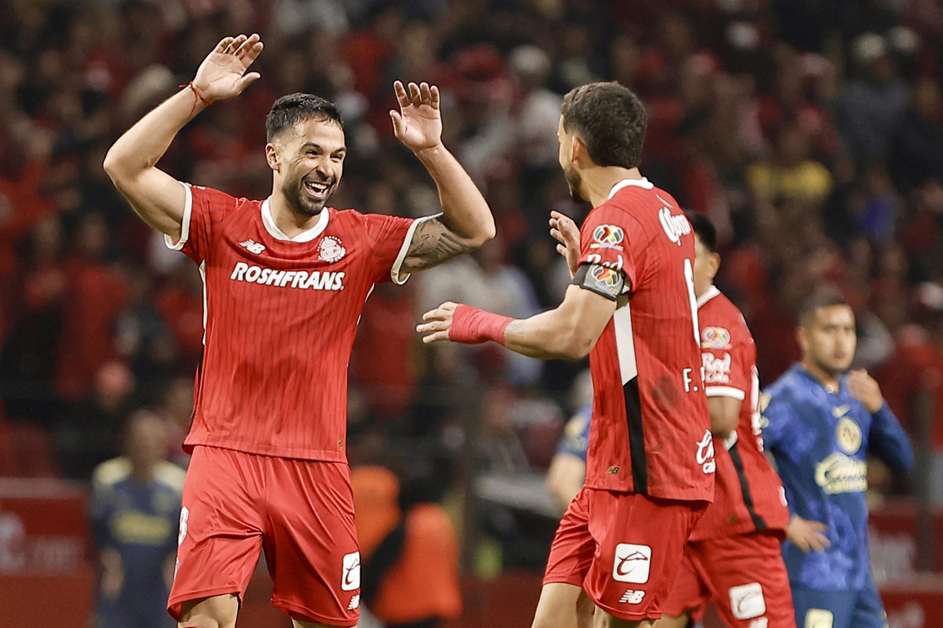 Luan García (i), de Toluca, fue registrado este sábado, 9 de noviembre, al celebrar un gol que le anotó a América, durante un partido de la jornada 17 del Torneo Apertura 2024 de la Liga MX del fútbol en México, en el estadio Nemesio Díez de Toluca. EFE/Alex Cruz