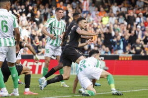 César Tárrega (c), del Valencia, supera la defensa del Real Betis para marcar el 1-0, durante el partido de la jornada 14 de Liga disputado este sábado en el estadio de Mestalla. EFE/Ana Escobar