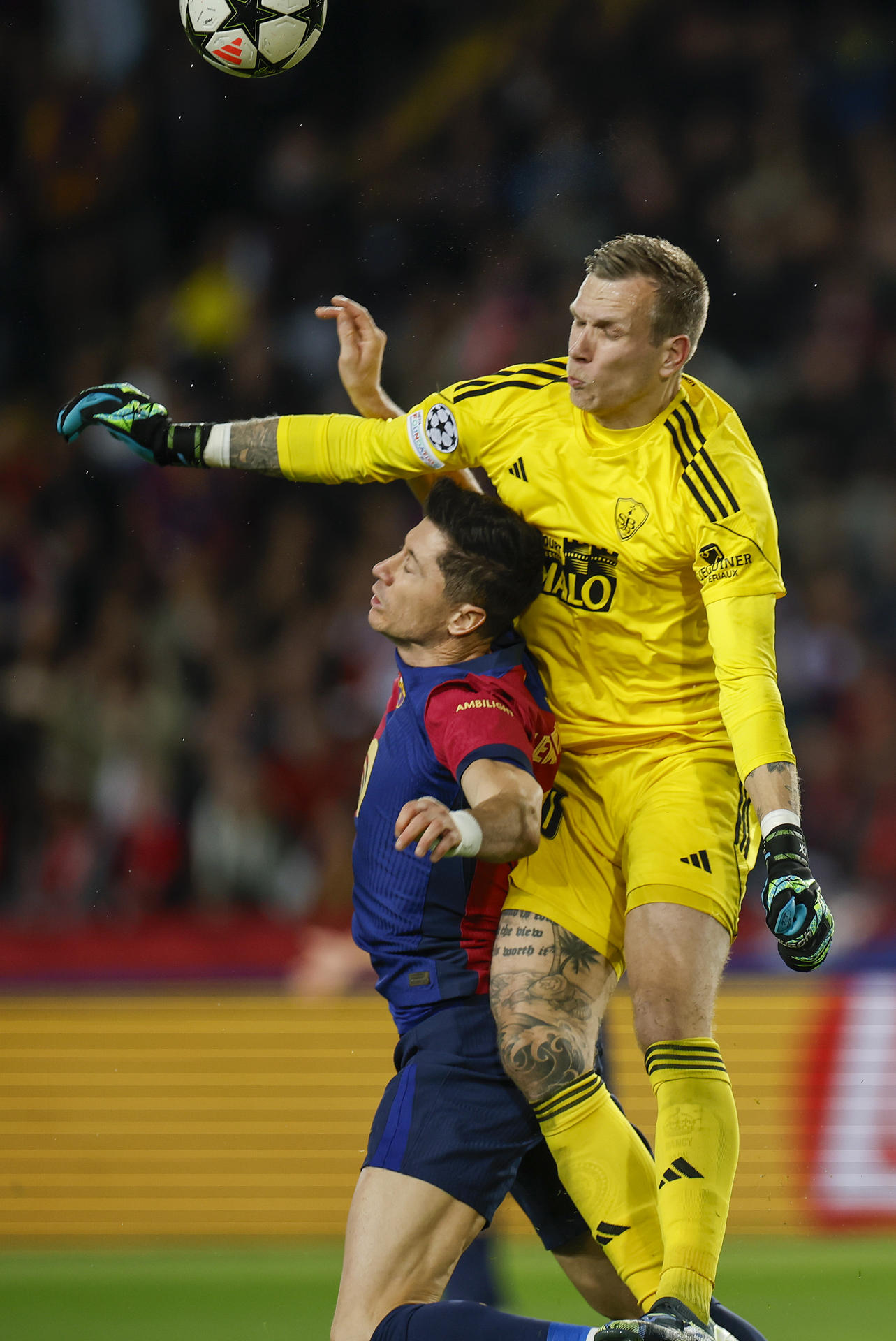 El guardameta neerlandés del Brest, Marco Bizot (d), comete penalti sobre el delantero polaco del FC Barcelona, Robert Lewandowski, durante el encuentro correspondiente a la fase regular de la Liga de Campeones en el estadio Lluis Company, en Barcelona. EFE / Alberto Estevez. 