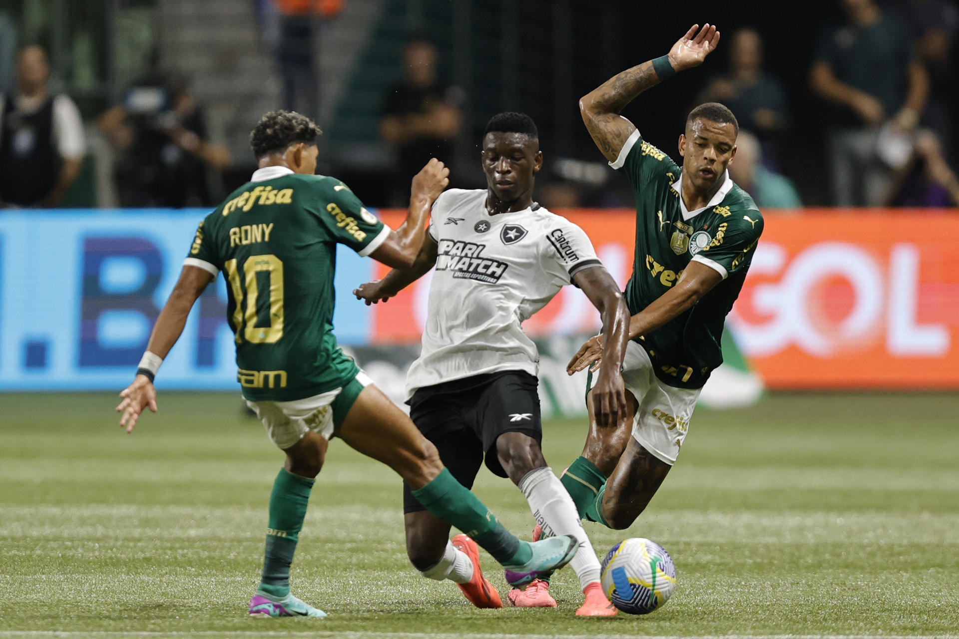 Rony (i) y Caio Paulista (d) de Palmeiras disputan un balón con Luiz Henrique de Botafogo en un partido del Brasileirao serie A. EFE/ Isaac Fontana 