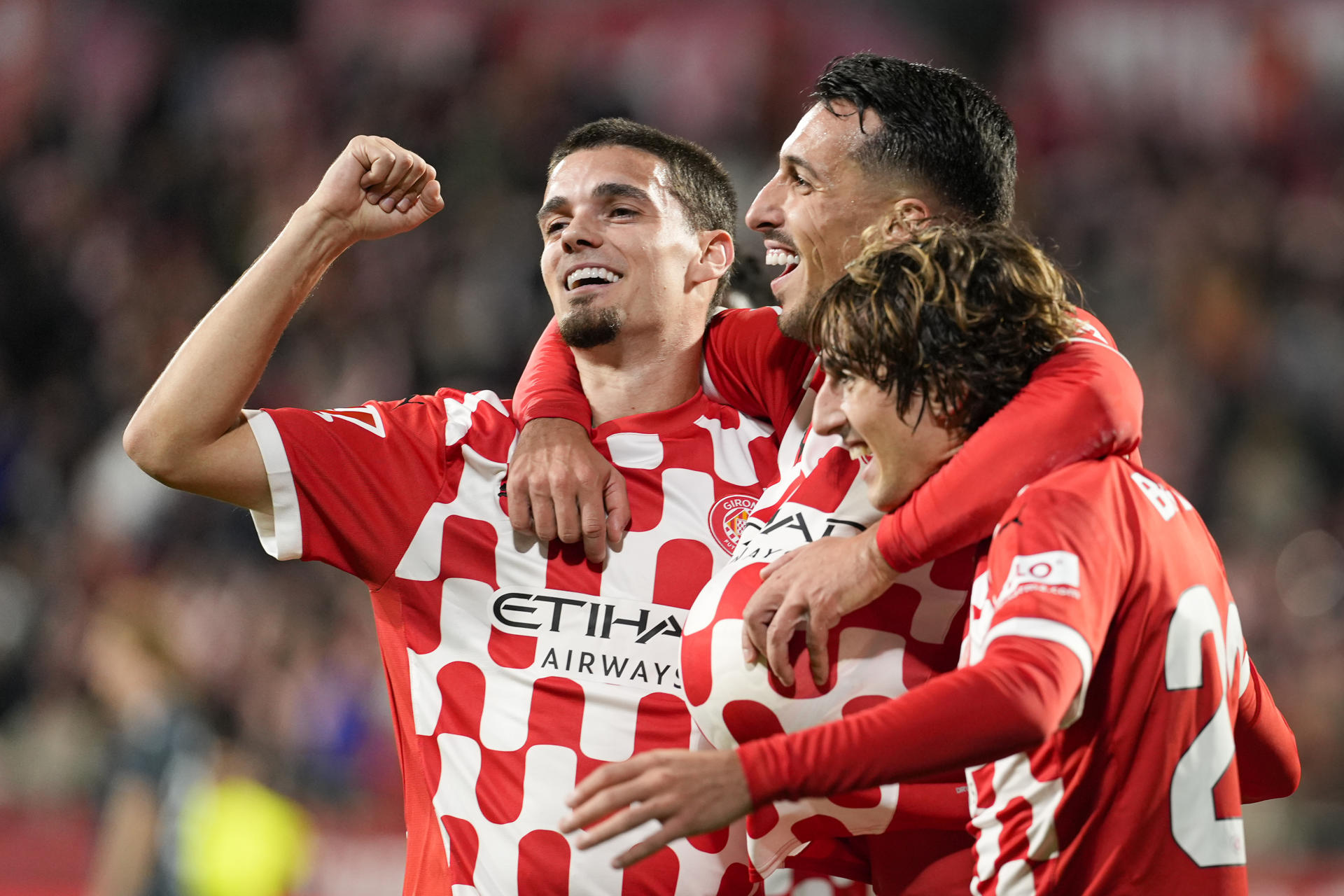 El delantero macedonio del Girona, Bojan Miovski (c), celebra con sus compañeros el tercer gol de su equipo durante el encuentro correspondiente a la jornada 14 de Laliga EA Sportsen el estadio de Montilivi, en Girona. EFE / David Borrat.
