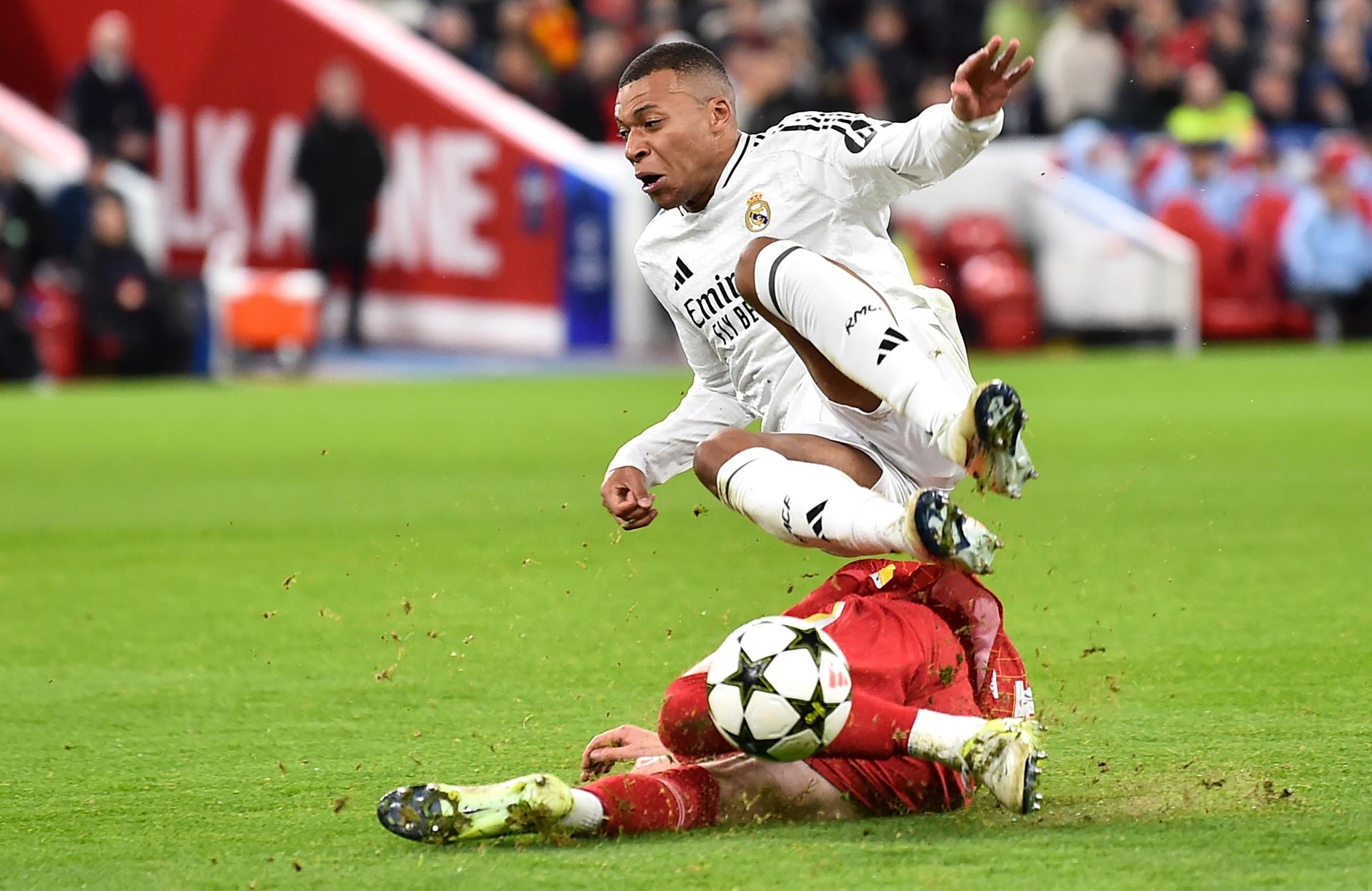 El joven Conor Bradley (abajo) frena el ataque del jugadpr del Madrid Kylian Mbappe durante el partido de la quinta jornada de la UEFA Champions League entre Liverpool y Real Madrid en Liverpool, Reino Unido.EFE/EPA/PETER POWELL 