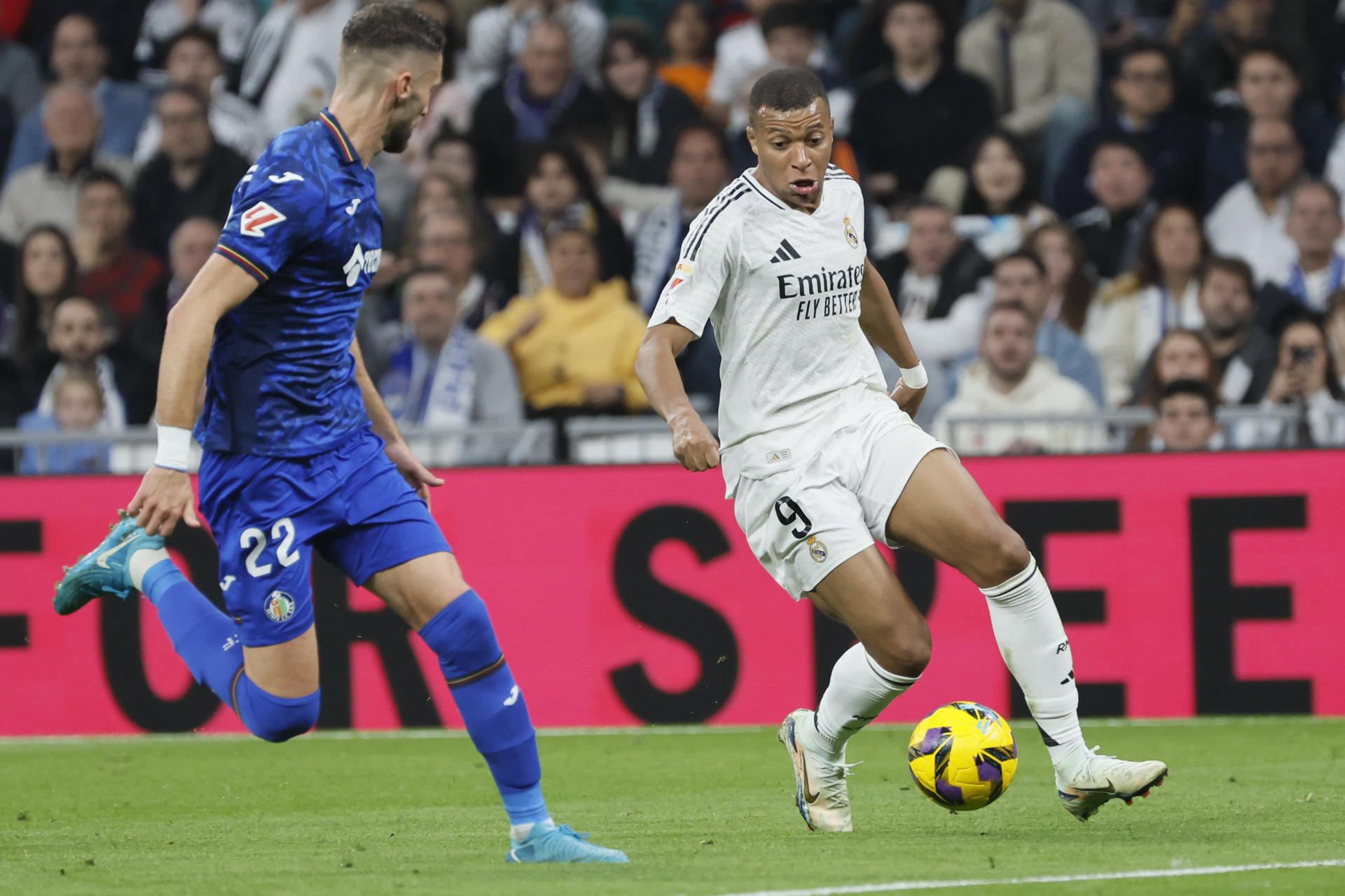 El delantero francés del Real Madrid Kylian Mbappé (d) controla el balón ante el defensa del Getafe Domingos Duarte (i) en el partido de LaLiga entre el Real Madrid y el Getafe, este domingo en el estadio Santiago Bernabéu. EFE/Ballesteros 