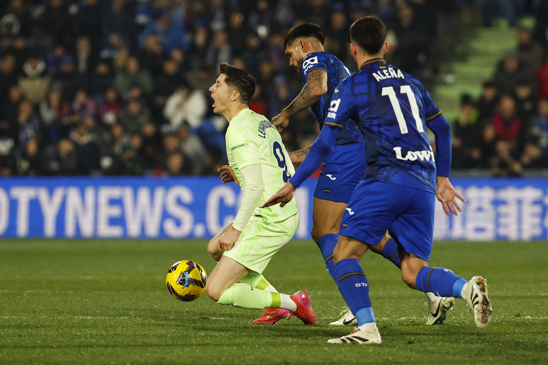 El delantero polaco del FC Barcelona, Robert Lewandowski (i), cae ante el defensa paraguayo del Getafe, Omar Alderete, durante el encuentro correspondiente a la jornada 20 de Laliga EA Sports que disputan Getafe y FC Barcelona en el Coliseum de Getafe. EFE / Chema Moya. 