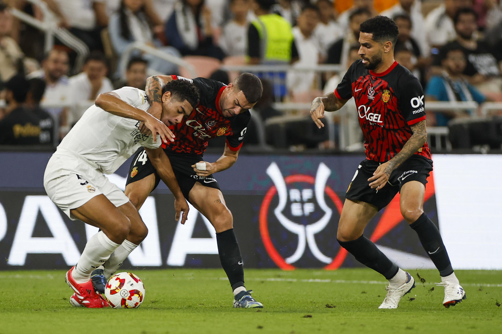 El centrocampista británico del Real Madrid Jude Bellingham (i) disputa un balón con Dani Rodríguez, del Mallorca, durante el partido de semifinales de la Supercopa de España de fútbol entre el Real Madrid y el RCD Mallorca, este jueves en Yeda. EFE/ Alberto Estévez