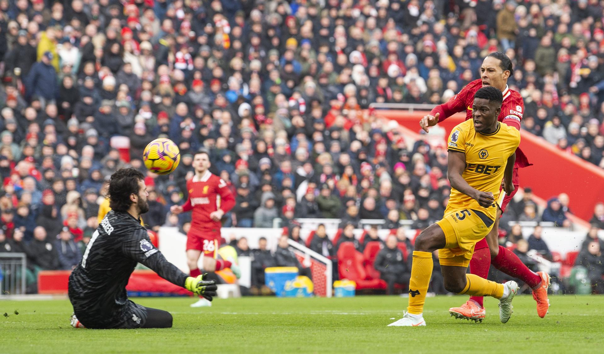 El portero del Liverpool Alisson Becker (L) evita el gol de Marshall Munetsim, del Wolverhampton durante el partido de la Premier League que han jugado Liverpool FC y Wolverhampton Wanderers, en Liverpool, (Reino Unido. EFE/EPA/PETER POWELL 