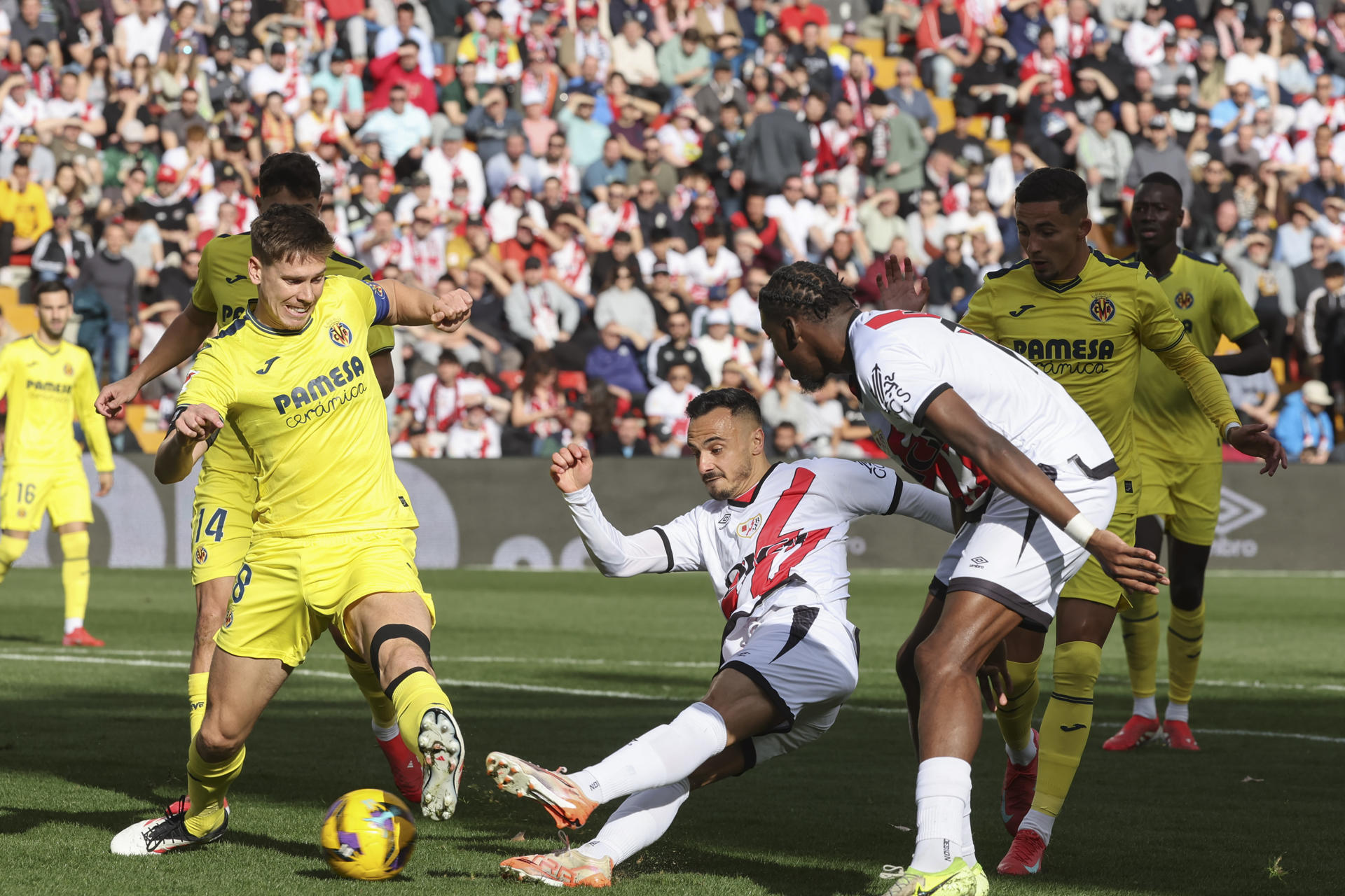 El defensa argentino del Villarreal Juan Foyth (i) controla el balón ante dos rivales del Villarreal, en el partido de LaLiga que se disputa este sábado en el estadio de Vallecas. EFE/ Kiko Huesca 