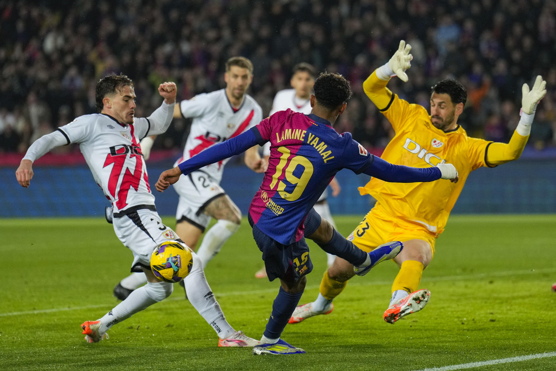 El delantero del Barcelona Lamine Yamal (c) en acción ante el portero argentino del Rayo Augusto Batalla (d), durante el partido de LaLiga de fútbol que FC Barcelona y Rayo Vallecano disputan en el estadio Lluis Companys. EFE/Alejandro García