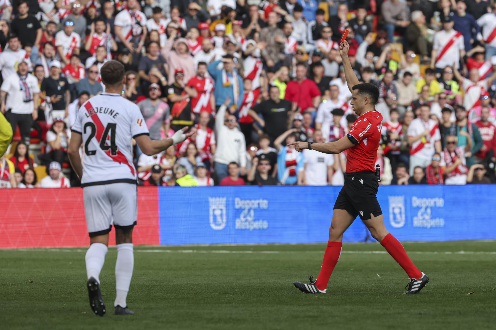 El colegiado muestra una cartulina roja al centrocampista del Rayo Jorge de Frutos (fuera de la imagen) en el partido entre el Rayo y el Villarreal, de LaLiga que se disputa este sábado en el estadio de Vallecas. EFE/ Kiko Huesca 