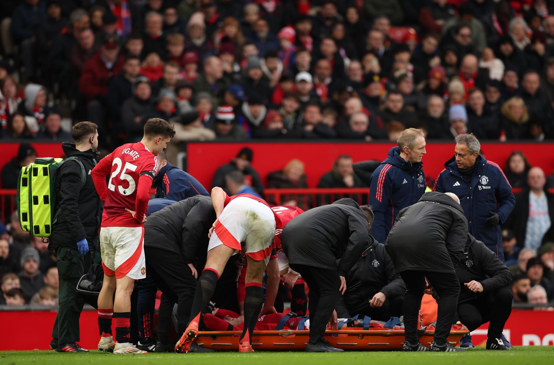 Los compañeros rodean a Lisandro Martínez del Manchester United mientras es trasladado en camilla durante el partido de la Premier League inglesa entre el Manchester United y el Crystal Palace en Manchester, Gran Bretaña. EFE/EPA/ADAM VAUGHAN 