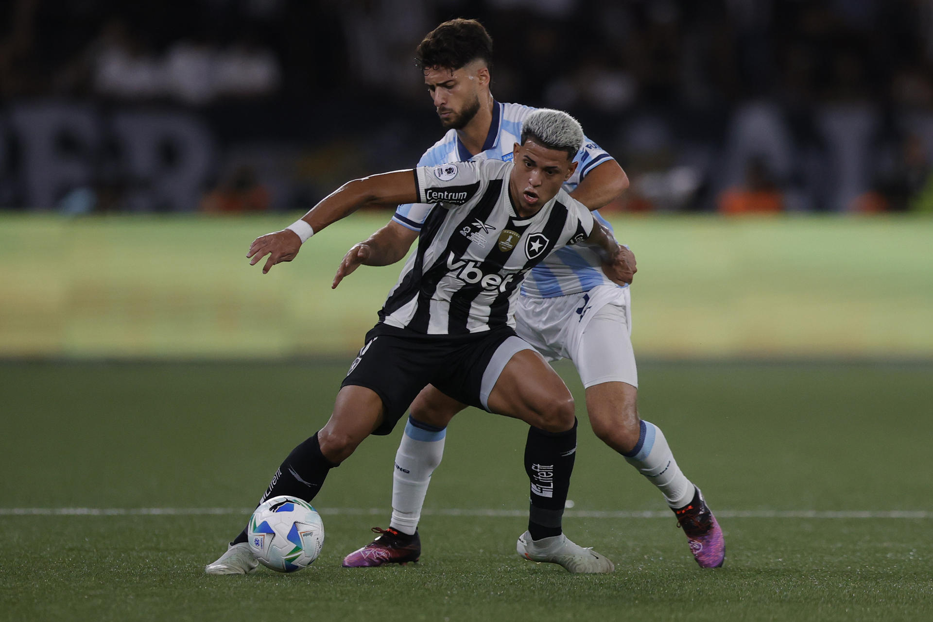 Matheus Martins (i) de Botafogo disputa un balón con Marco Di Cesare de Racing en la final de la Recopa Sudamericana. EFE/ Andre Coelho 