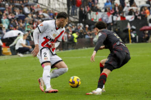 El lateral rumano del Rayo Vallecano Andrei Rațiu (i) disputa un balón ante el centrocampista suizo del Sevilla Ruben Vargas este sábado, en el partido de la jornada 26 de LaLiga EA Sports, entre el Rayo Vallecano y el Sevilla FC, en el estadio de Vallecas, en Madrid. EFE/ Zipi Aragón