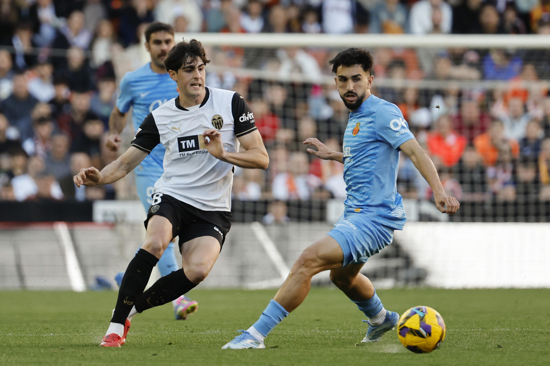 El centrocampista del Valencia Javier Guerra y el centrocampista del Mallorca Manuel Morlanes, durante el partido de la jornada 29 de LaLiga entre Valencia CF y RCD Mallorca, este domingo en el estadio de Mestalla.-EFE/ Ana Escobar