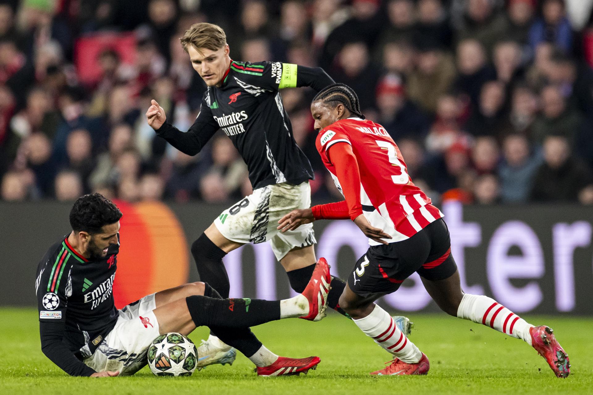 Mikel Merino (I) y Martin Odegaard (c), ambos del Arsenal FC, durante el partido de octavos de final de la Liga de Campeones que han jugado PSV Eindhoven y Arsenal FC en Eindhoven, Países Bajos. EFE/EPA/ROBIN VAN LONKHUIJSEN 