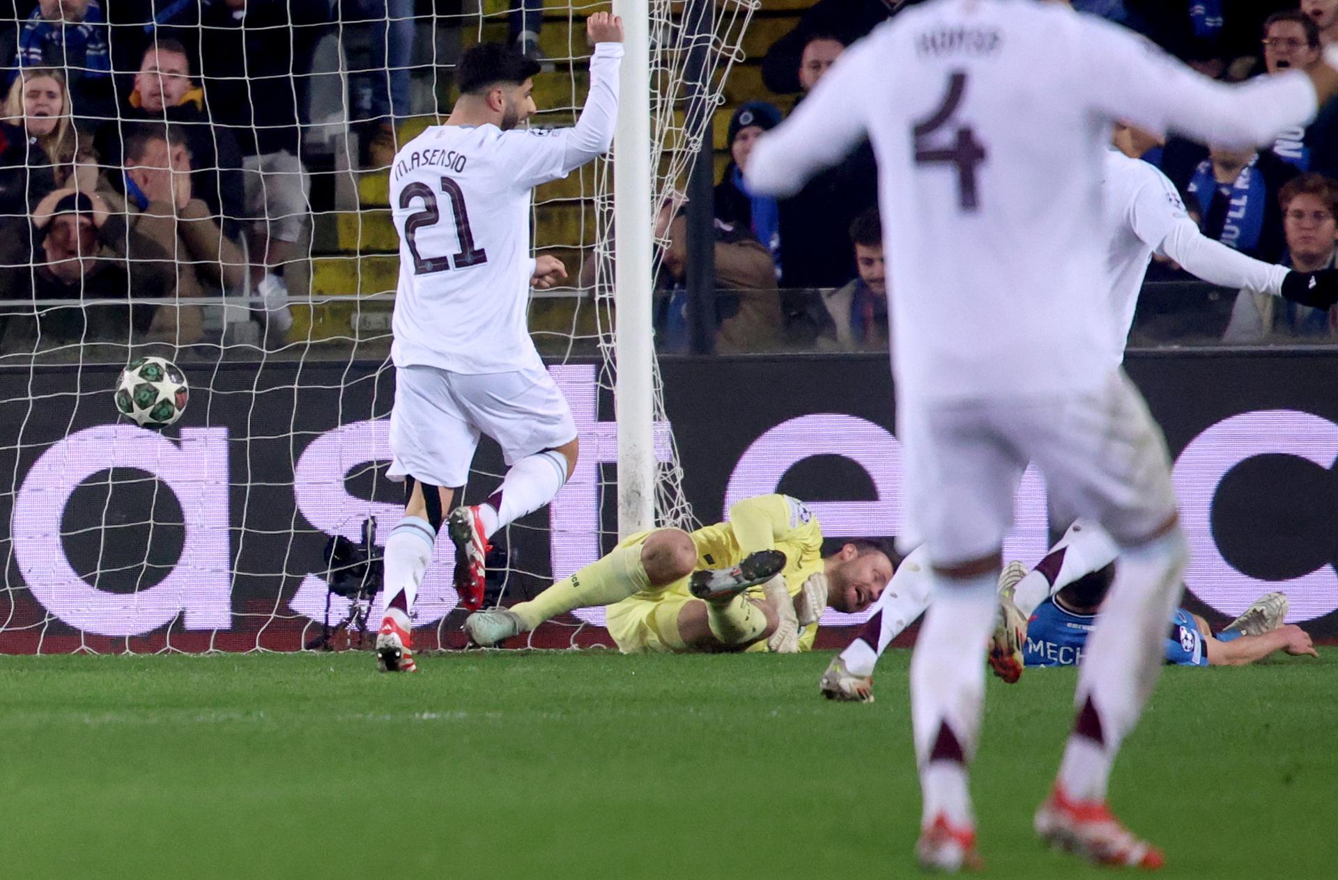 El portero del Brujas Simon Mignolet (c) no puede detener el remate en propia puerta de su compañero Brandon Mechele, mientras el español Marco Asensio, del Aston Villa, celebra el gol durante el partido de la UEFA Champions League que han jugado Club Brugge KV y Aston Villa FC, en Brujas, Bélgica EFE/EPA/OLIVIER MATTHYS 