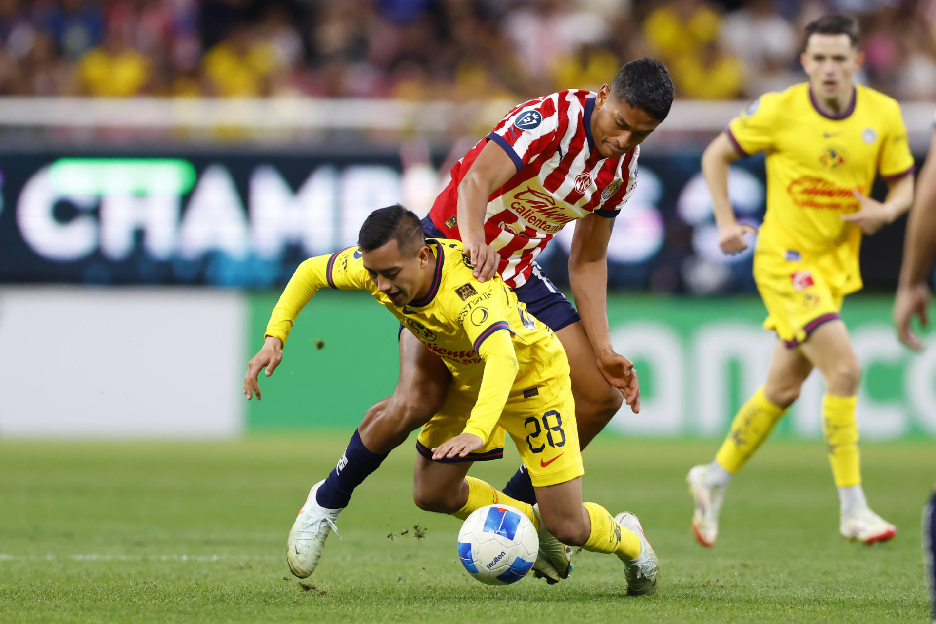 Luis Romo (d) de Guadalajara disputa el balón con Erick Sánchez (i) de América este miércoles, en el partido de ida de los octavos de final de la Copa de Campeones Concacaf entre Guadalajara y América en el Estadio Akron en Guadalajara (México). EFE/ Francisco Guasco
