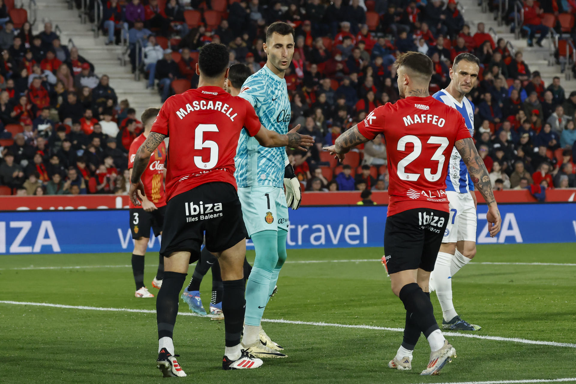 Los jugadores del Mallorca Pablo Maffeo (d) y Omar Mascarell (i), y el guardameta del equipo, Dominik Greif (c), durante el partido de LaLiga EA Sports entre RCD Mallorca y Deportivo Alavés, este domingo en el Estadio de Son Moix. EFE/ Cati Cladera 