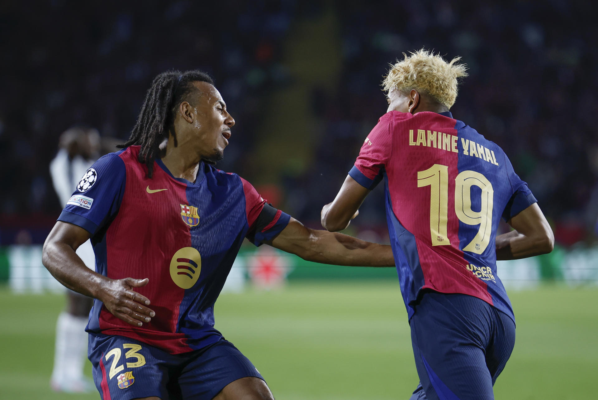 El delantero del Barcelona Lamine Yamal (d) anota el primer gol del equipo durante el encuentro correspondiente a la ida de las semifinales de la Liga de Campeones que disputaron FC Barcelona e Inter en el estadio Olímpico Lluis Company, en Barcelona. EFE / Alberto Estevez. 