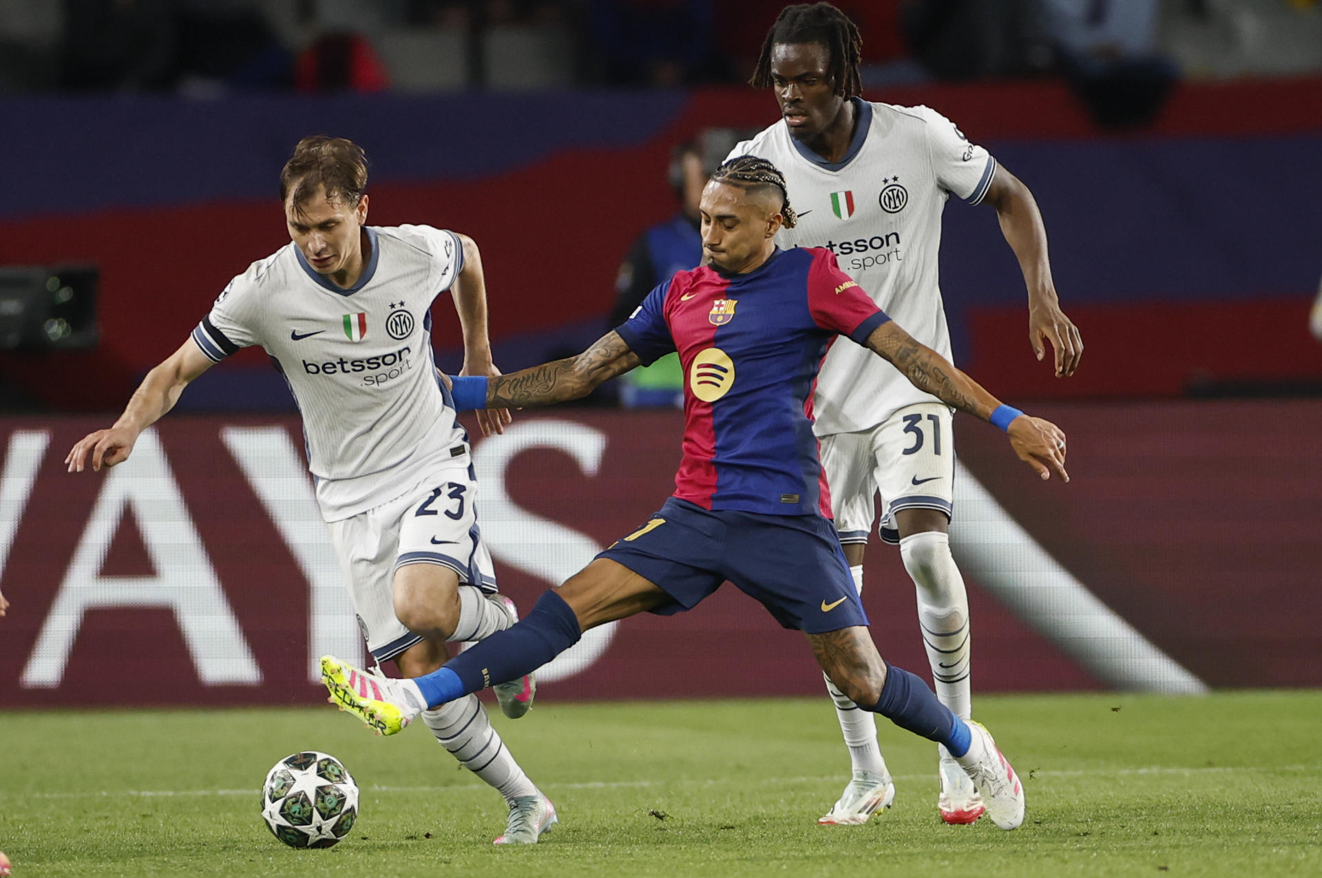 El centrocampista del Inter, Nicolò Barella (i), intent llevarse el balón ante el delantero brasileño del FC Barcelona, Raphinha, durante el encuentro correspondiente a la ida de las semifinales de la Liga de Campeones que disputaron FC Barcelona e Inter en el estadio Olímpico Lluis Company, en Barcelona. EFE / Alberto Estevez. 