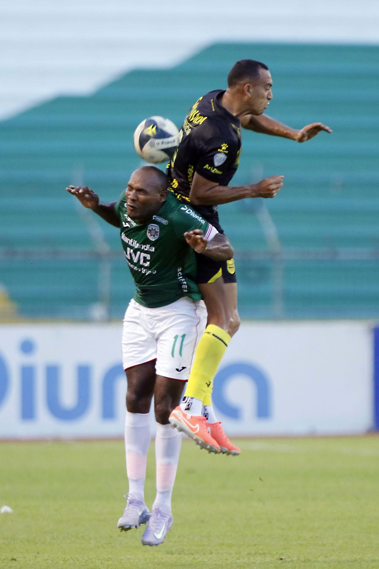 Juan Anangonó (i) disputa el balón con Devron García (d) del Real España este domingo, durante el clásico que Marathón ganó en el estadio Olímpico de San Pedro Sula (Honduras). EFE/Jose Valle 