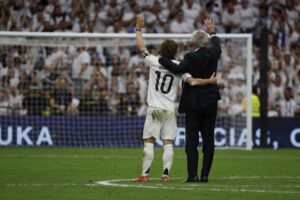 El entrenador del Real Madrid, Carlo Ancelotti (d), y el centrocampista croata Luka Modrić (i) reciben un homenaje tras su último partido en el Santiago Bernabéu al término del encuentro de la jornada 38 de LaLiga EA Sports entre Real Madrid y Real Sociedad celebrado este sábado en el estadio Santiago Bernabéu de Madrid. EFE/ J.J.Guillén