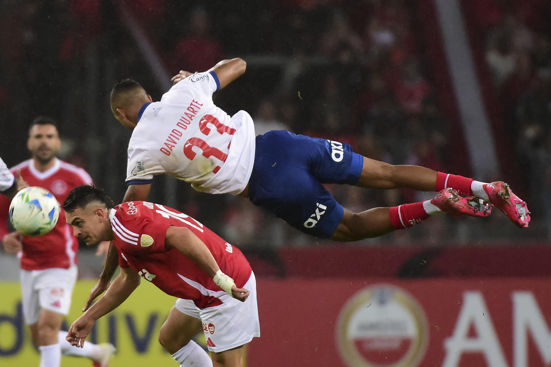 Rafael Santos Borré (abajo) de Internacional disputa un balón con David Macedo de Bahia por la Copa Libertadores. EFE/Ricardo Rimoli