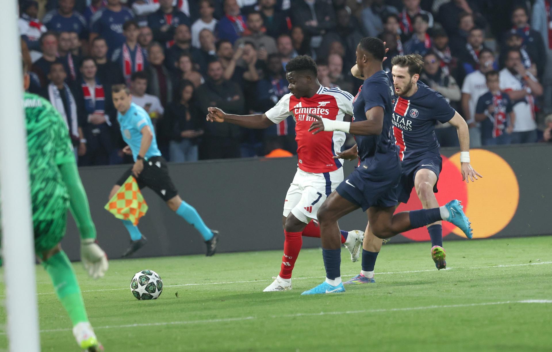 El extremo del Arsenal Bukayo Saka (I) en acción ante el defensa del PSG Willian Pacho (C) y el extremo Khvicha Kvaratskhelia, del PSG, durante el partido de vuelta de semifinales de la UEFA Champions League en París. EFE/EPA/MOHAMMED BADRA