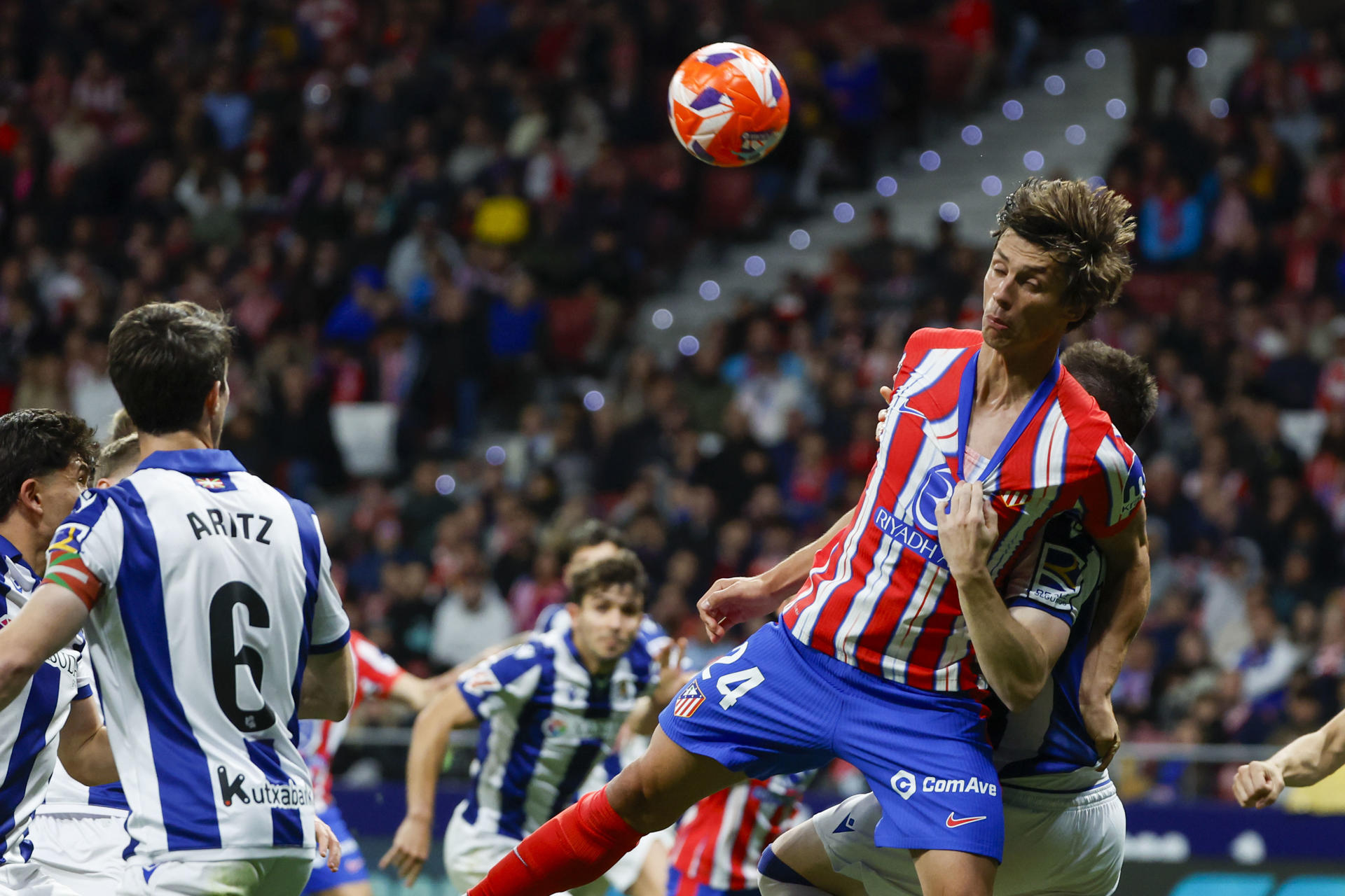 El defensa del Atlético de Madrid, Robin Le Normand, intenta rematar sujetado por el defensor de la Real Sociedad durante el encuentro correspondiente a la jornada 35 de Laliga EA Sports que disputaron Atlético de Madrid y Real Sociedad en el Riyadh Air Metropolitano en Madrid. EFE / Juanjo Martín.