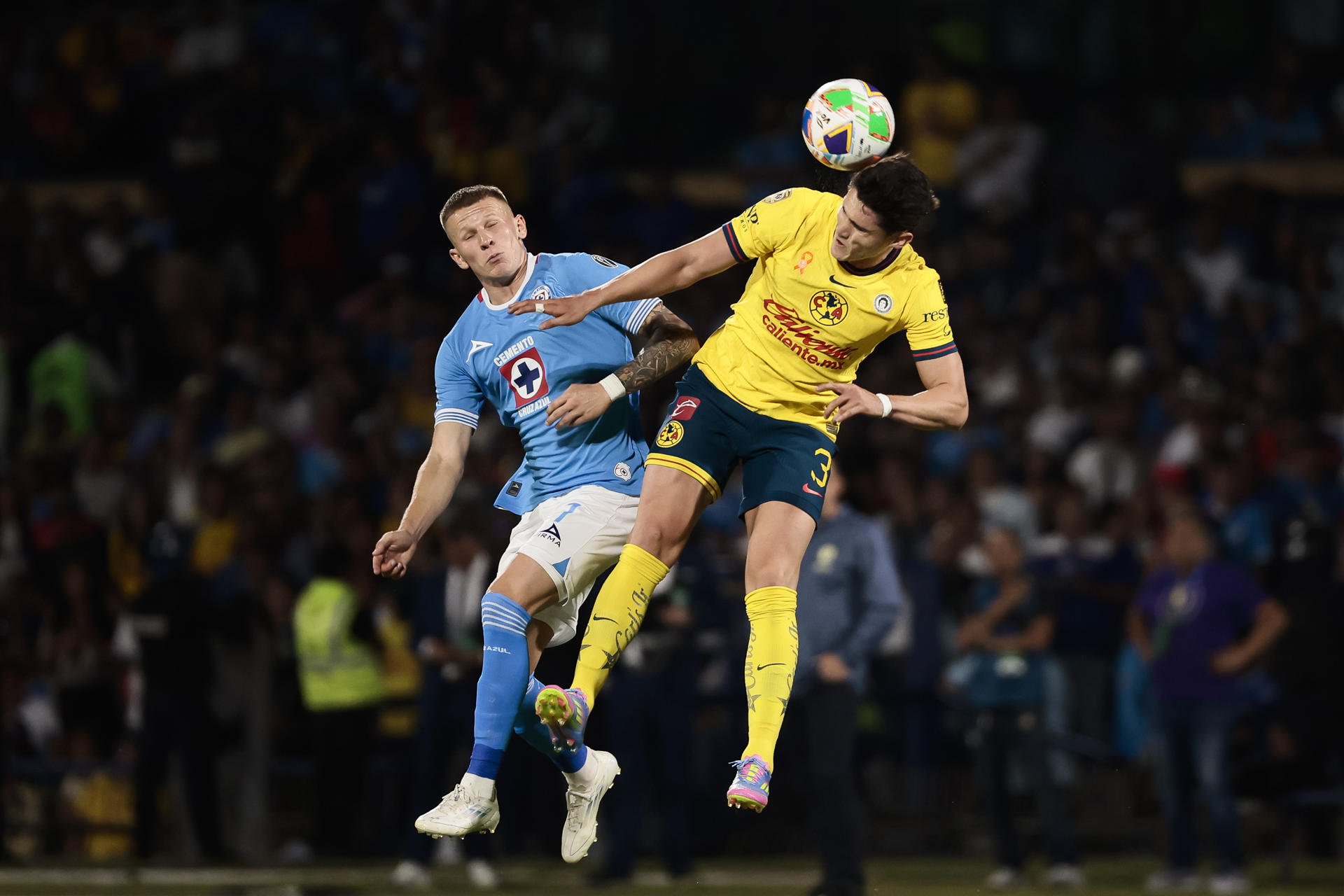 Mateusz Bogusz (i) de Cruz Azul disputa el balón con Israel Reyes de América este jueves, en un partido de ida de semifinal del Torneo Clausura 2025 Liga MX entre Cruz Azul y América en el estadio Olímpico Universitario en Ciudad de México (México). EFE/ José Méndez