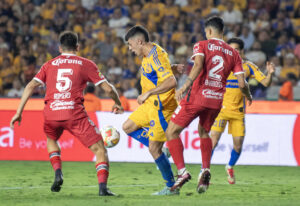 Juan Brunetta (c) de Tigres disputa un balón con Diego Barbosa (d) y Franco Romero de Toluca ayer miércoles, durante el partido de ida de la semifinal del Torneo Clausura 2025 Liga MX entre Tigres y Toluca en el estadio Universitario de la ciudad de Monterrey (México). EFE/ Miguel Sierra