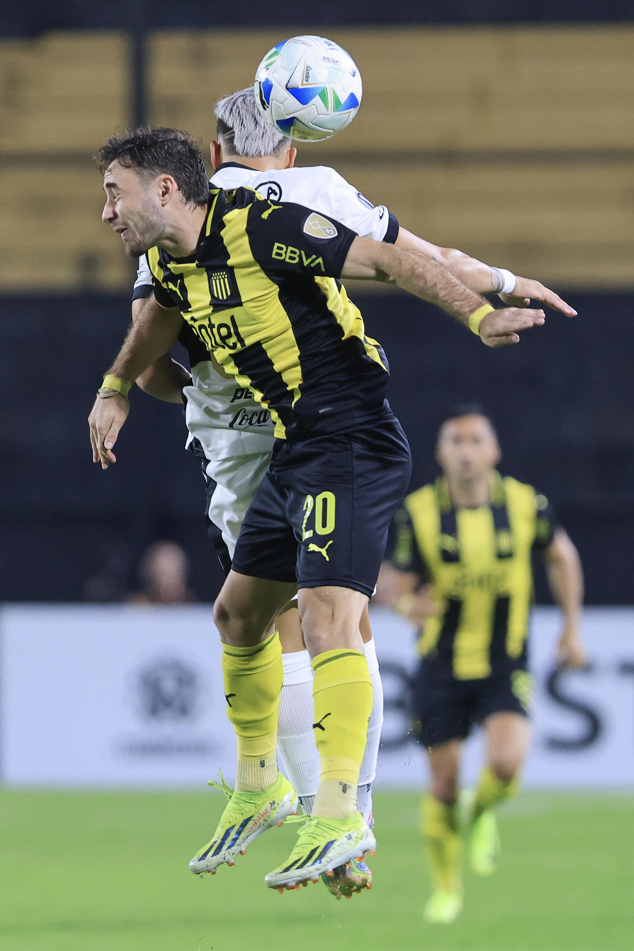 Pedro Milans (frente) de Peñarol disputa un balón con Iván Leguizamón de Olimpia este miércoles en el partido que clasificó al Aurinegro a los octavos de final de la Copa Libertadores con un triunfo por 3-2 en el estadio Campeón del Siglo de Montevideo. EFE/ Gastón Britos