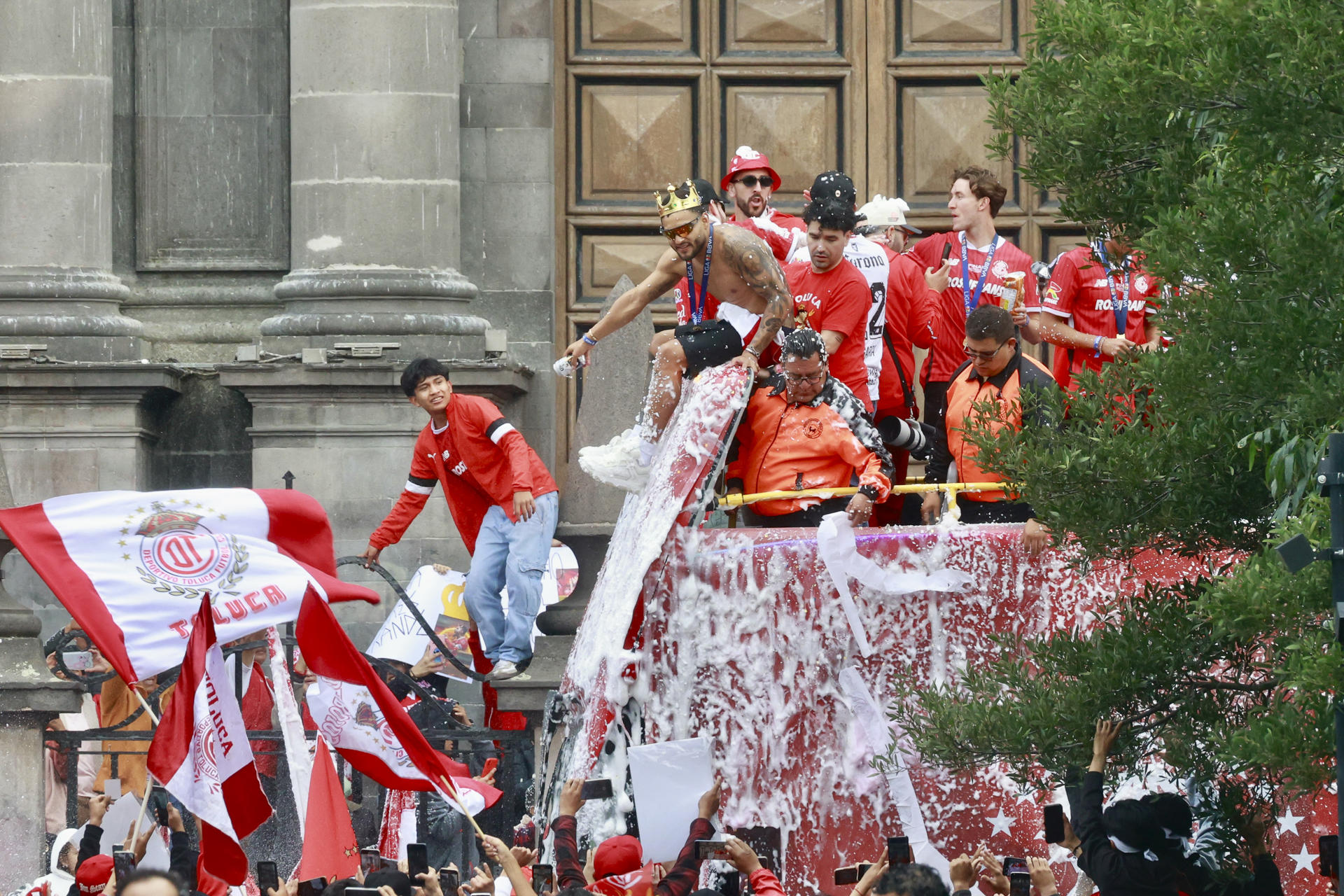 Alexis Vega (c) y otros jugadores de los Diablos Rojos de Toluca festejan junto a aficionados el campeonato de la Liga MX, este lunes en calles de la ciudad de Toluca (México). EFE/ Felipe Gutiérrez