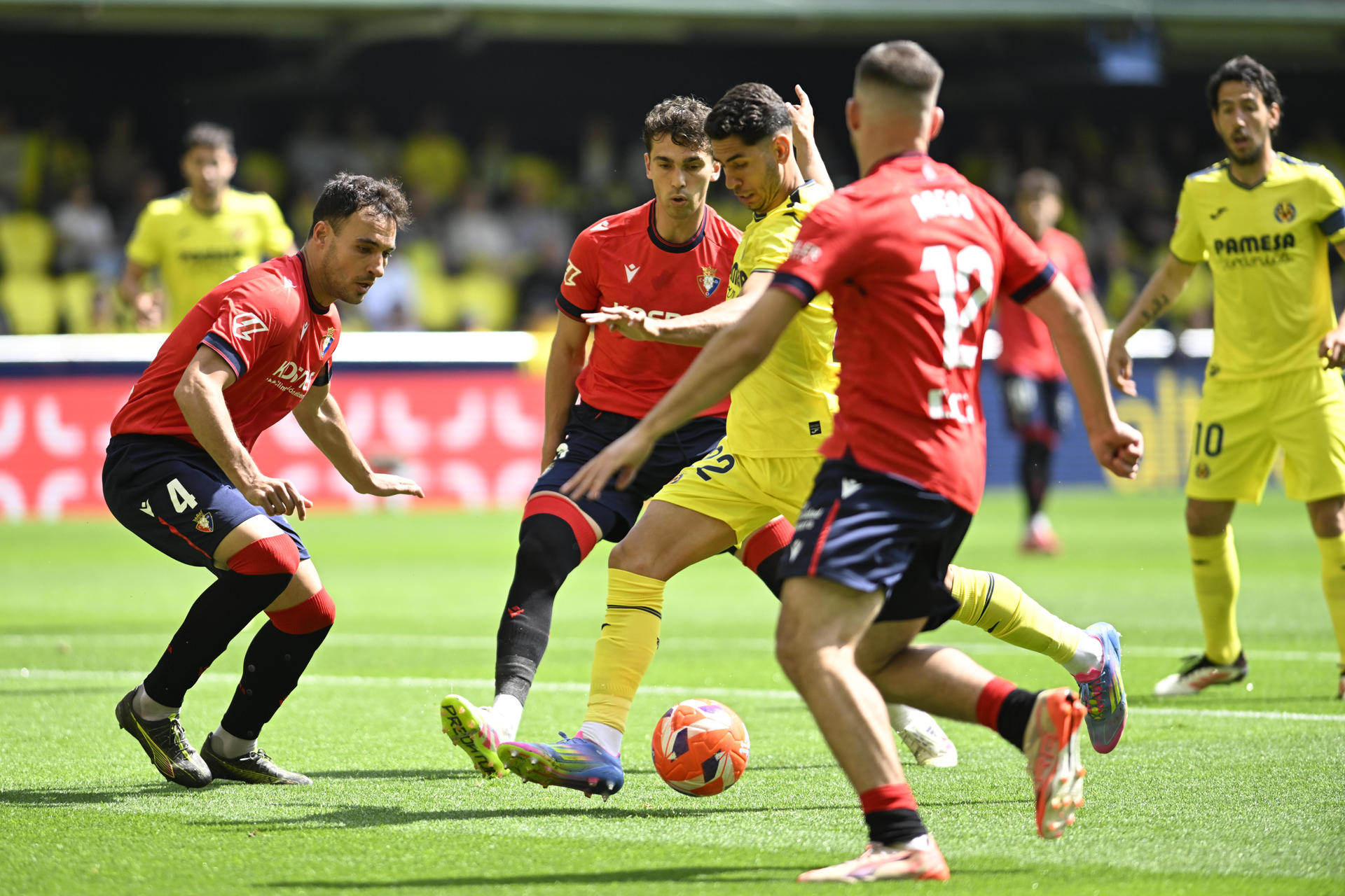 El delantero del Villarreal Ayoze Pérez (c) chuta rodeado de adversarios para anotar un tanto este sábado durante el partido de la jornada 34 de LaLiga EA Sports, entre el Villarreal CF y el CA Osasuna, celebrado en el Estadi de la Ceràmica en Villarreal. EFE/ Andreu Esteban