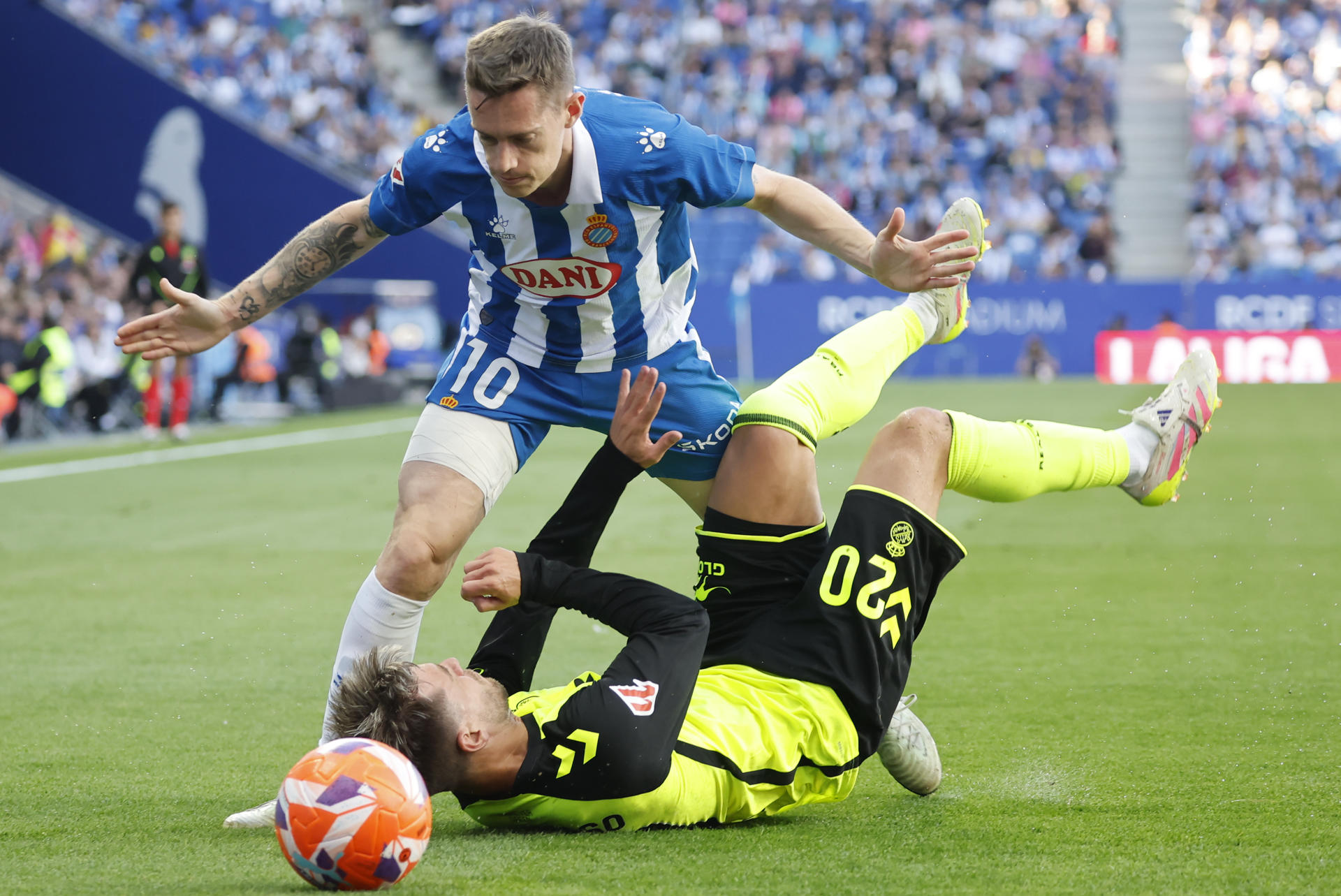El centrocampista del Espanyol Pol Lozano (i) pelea un balón ante el centrocampista argentino del Betis Giovani Lo Celso este domingo, durante el partido de la jornada 34 de LaLiga EA Sports, entre el RCD Espanyol y el Real Betis Balompié, en el RCDE Stadium de Cornellà de Llobregat (Barcelona). EFE/ Andreu Dalmau