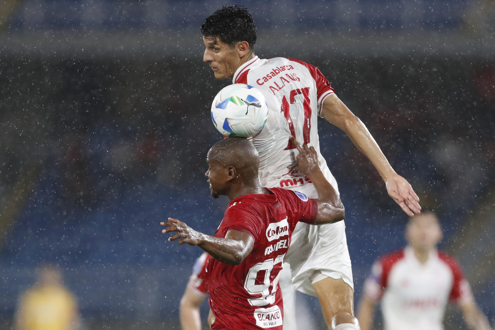 Yerson Candelo (i) de América disputa un balón con Gabriel Alanís de Huracán. EFE/ Ernesto Guzmán Jr.