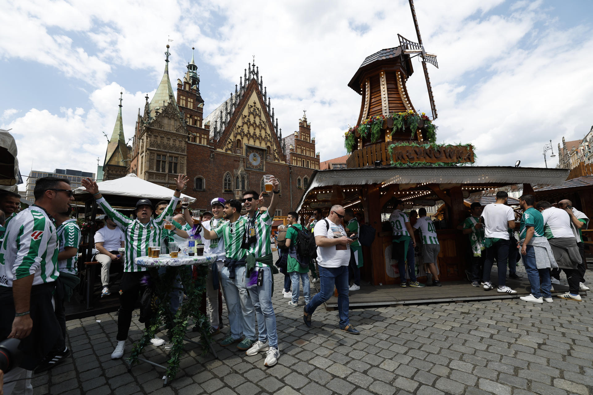 Aficionados del Betis en la Plaza Solny de Breslavia (Polonia) cantan y beben un día antes de la final de la Liga Conferencia, en la que el equipo verdiblanco tiene una cita con la historia y se enfrenta ante uno de los grandes del fútbol europeo, el Chelsea inglés.EFE/Julio Muñoz