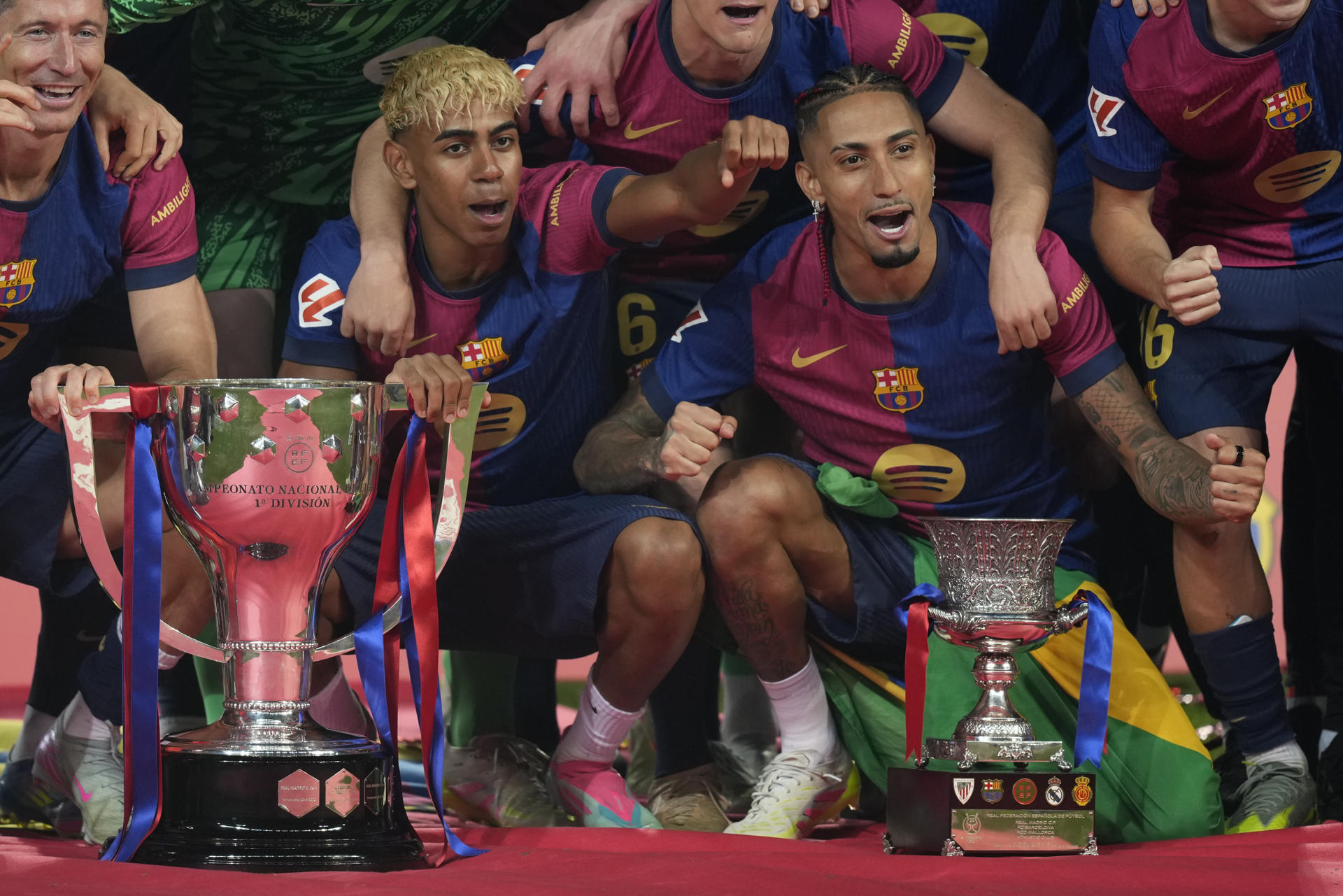 Los jugadores del Barcelona Lamine Yamal y Raphinha celebran el título de Liga con sus compañeros al final del encuentro de la jornada 37 de LaLiga entre FC Barcelona y Villarreal CF disputado este domingo en el Estadio Olímpico de Montjuic. EFE/ Enric Fontcuberta
