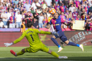 El delantero del Barcelona Raphinha, y el portero del Real Madrid Thibaut Courtois, durante el partido de la jornada 35 de LaLiga EA Sports entre el Barcelona y el Real Madrid, este domingo en el Estadi Olímpic Lluís Companys.-EFE/ Siu Wu