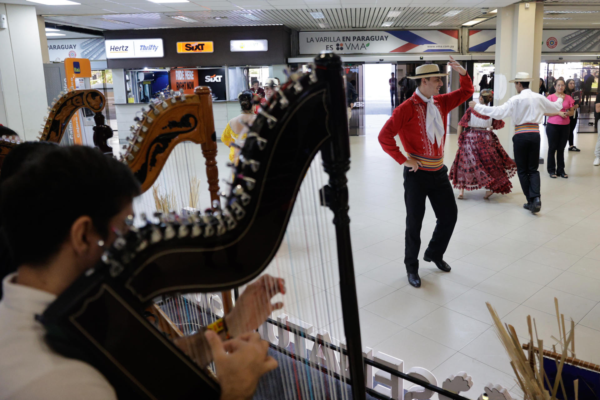 Asistentes al 75° Congreso Ordinario de la FIFA son recibidos con bailes típicos de Paraguay en el Aeropuerto Internacional Silvio Petirossi, en Luque (Paraguay). EFE/ Juan Pablo Pino