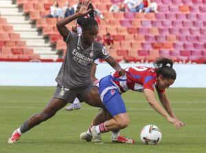 La defensa del Granada Alba Pérez (d) pelea un balón ante la delantera colombiana del Real Madrid Linda Caicedo este domingo durante el partido de la jornada 28 de la Liga F que enfrenta al Granada CF con el Real Madrid, en el Nuevo estadio de los Carmenes de Granada (Andalucía). EFE/ Pepe Torres