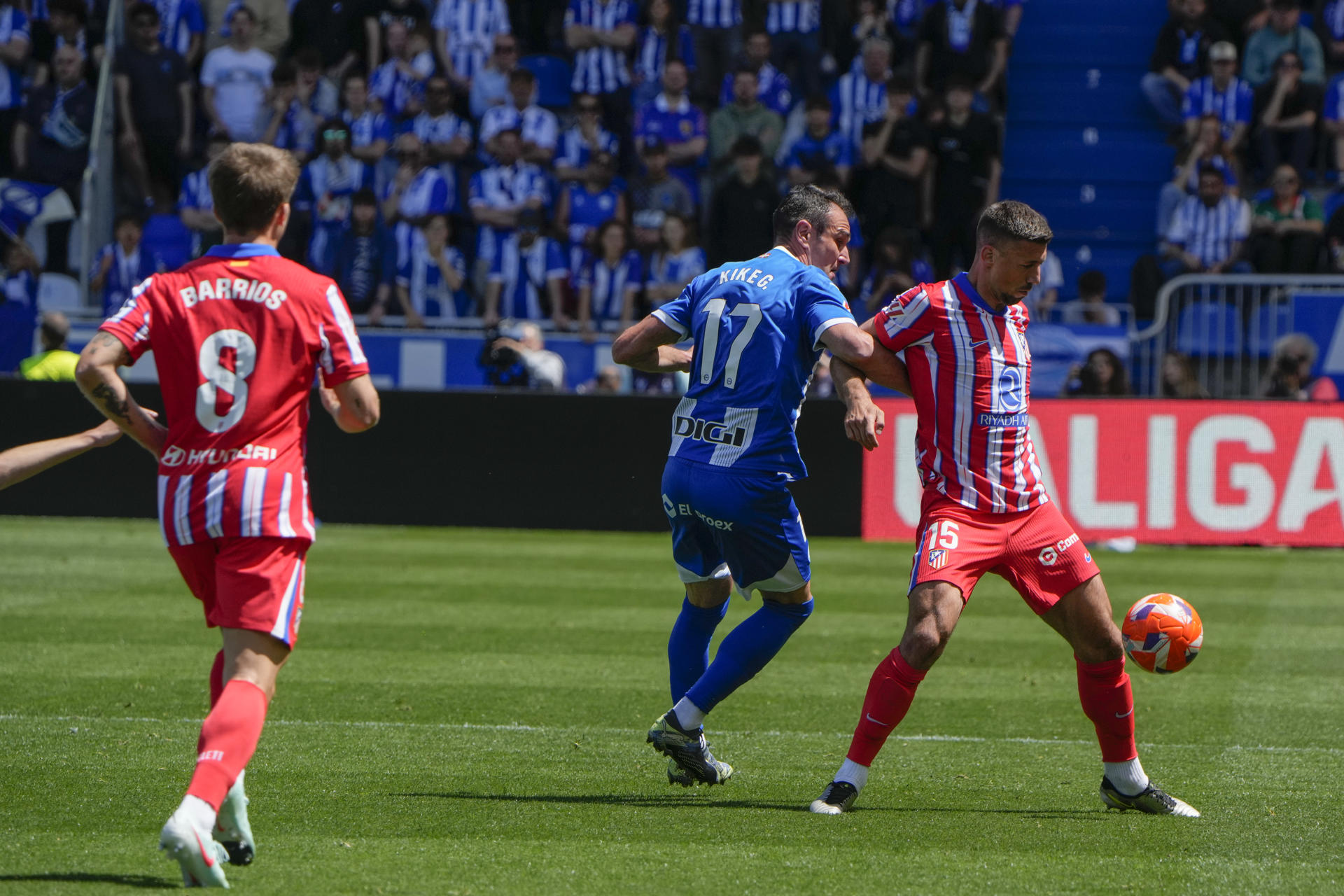 Pablo Barrios (i) y Clément Laurent (d), del Atlético de Madrid, luchan por el balón con Kike García (c), del Deportivo Alavés, durante el partido de LaLiga que enfrentó a sus equipos en el estadio de Mendízorrotza en Vitoria-Gasteiz. EFE/Adrián Ruiz Hierro