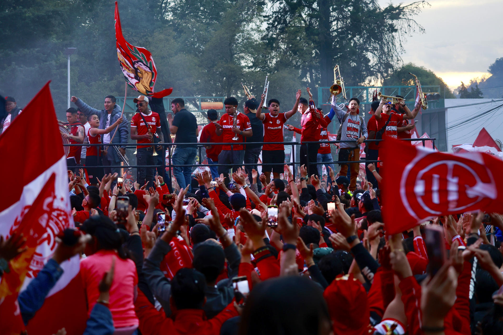 Miles de aficionados festejan a los campeones de la Liga Mx, los Diablos Rojos de Toluca, quienes este lunes recorrieron en un autobús las principales calles de la ciudad de Toluca (México). EFE/ Felipe Gutiérrez