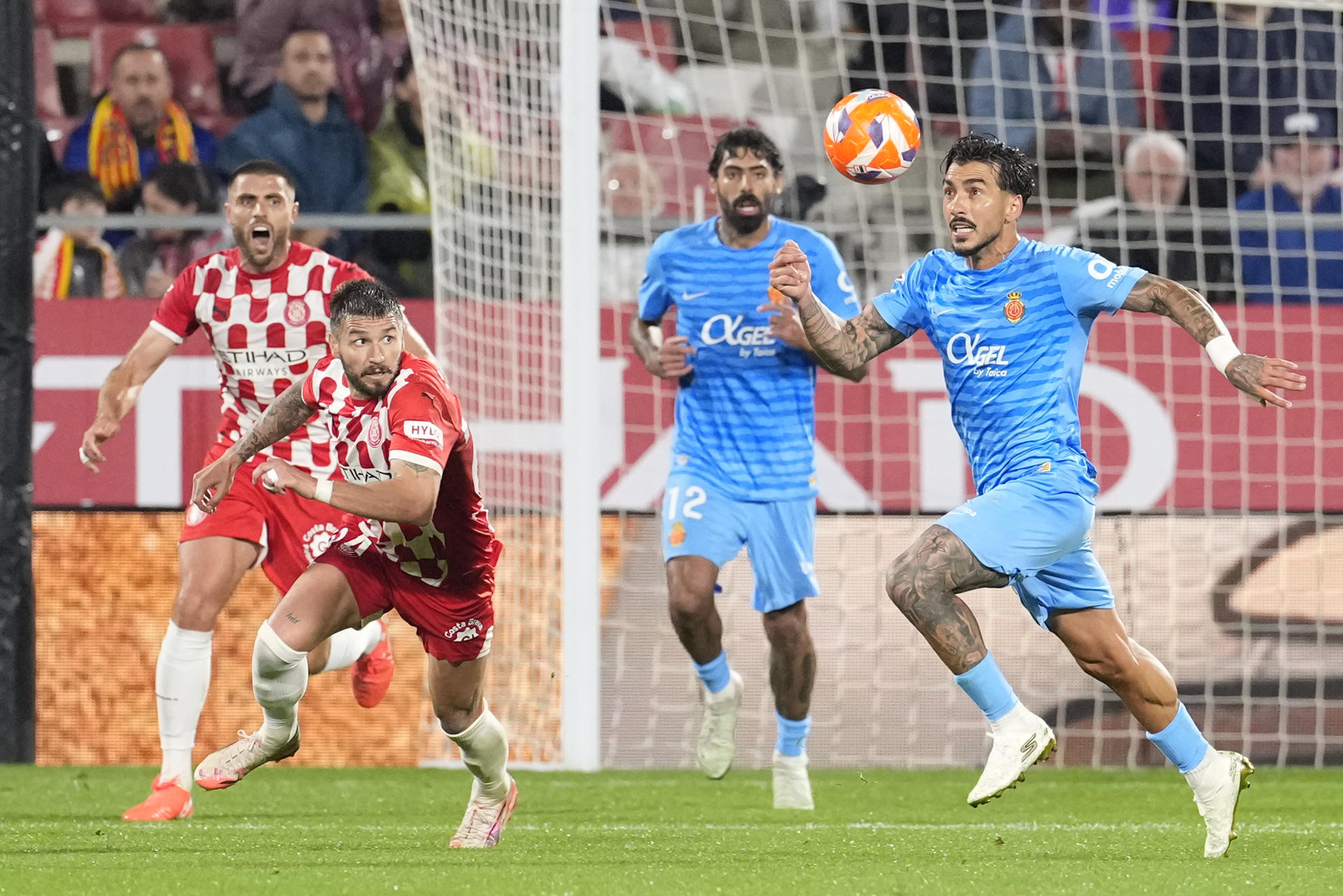 El delantero español del Girona Portu (i) disputa un balón con el centrocampista español del Mallorca Antonio Sánchez (d) durante el partido de LaLiga de fútbol que Girona FC y Real Mallorca disputaron en el estadio de Montilivi. EFE/ David Borrat
