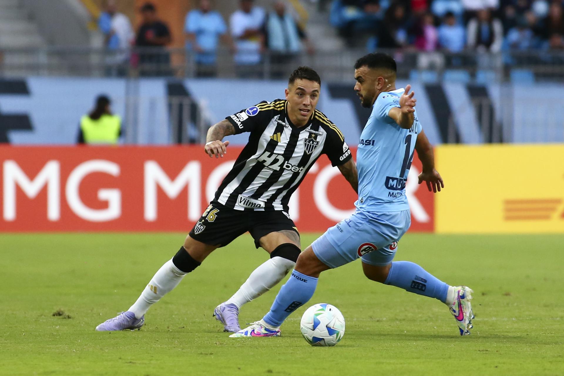 Misael Dávila (d) de Iquique disputa un balón con Renzo Saravia de Mineiro en un partido de la fase de grupos de la Copa Sudamericana. EFE/ Alex Díaz