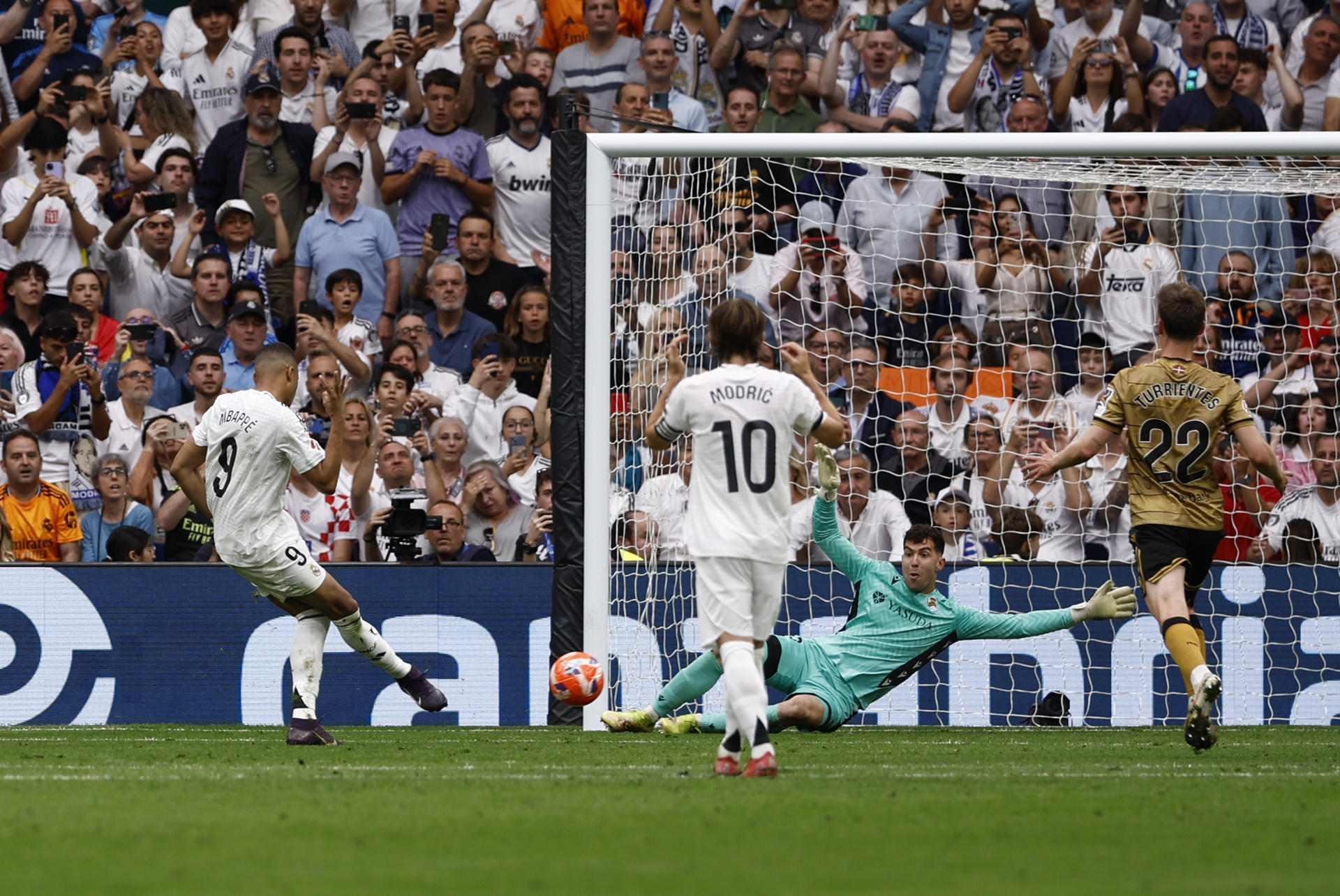 El delantero francés del Real Madrid Kylian Mbappé (i) marca el 1-0 durante el partido de la jornada 38 de LaLiga EA Sports entre Real Madrid y Real Sociedad celebrado este sábado en el estadio Santiago Bernabéu de Madrid. EFE/ Daniel González