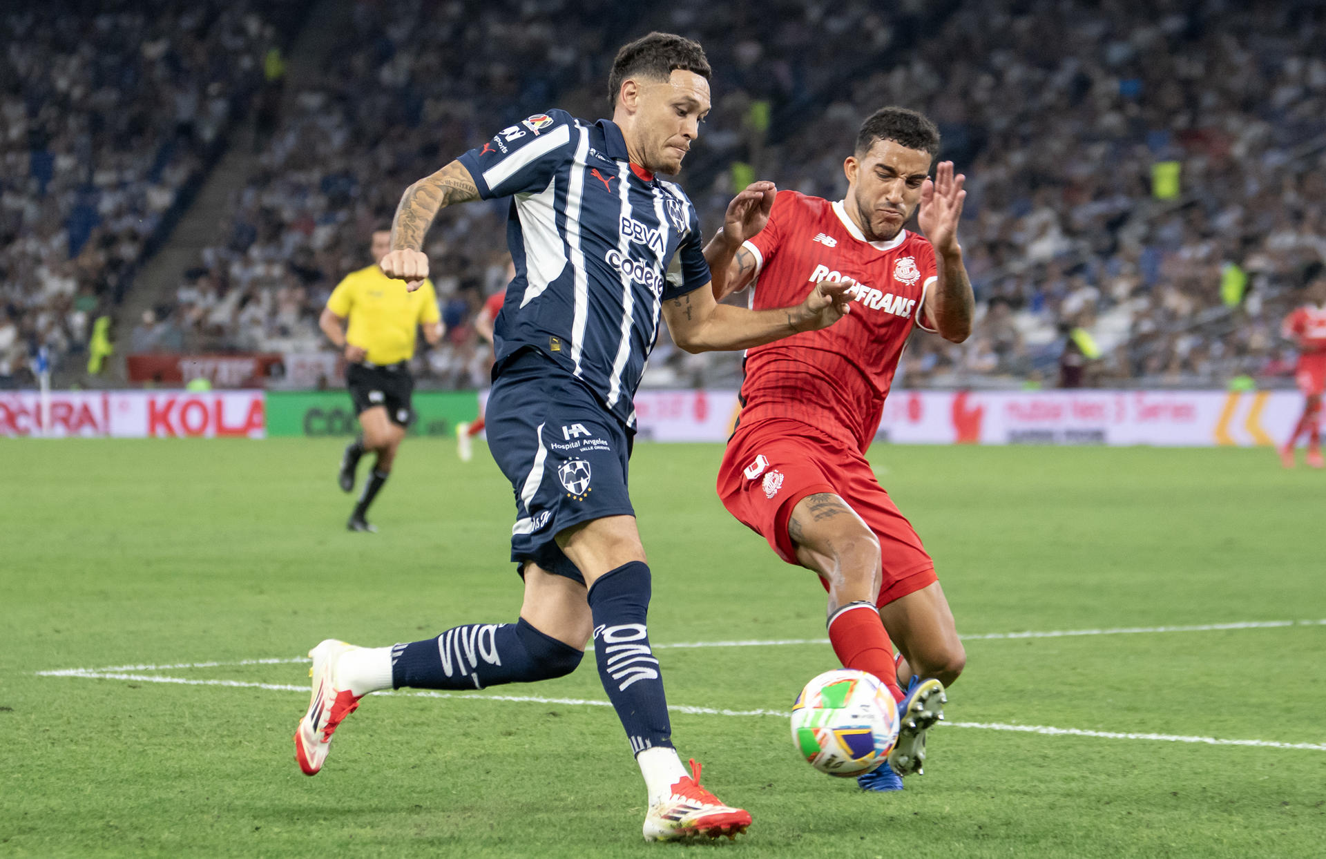 Lucas Ocampos (i) de Monterrey disputa el balón con Federico Pereira de Toluca este miércoles, durante el partido de ida de cuartos de final del Torneo Clausura 2025 de la Liga MX entre Monterrey y Toluca, en el Estadio BBVA de Monterrey (México). EFE/Miguel Sierra