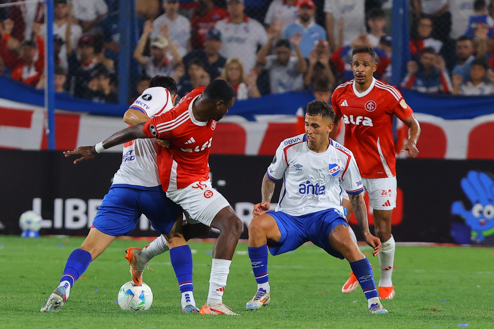 Paolo Calione (i) y Christian Oliva (c), de Nacional, disputan un balón con Ricardo Mathias (2-i), de Internacional, durante un partido de la fase de grupos de la Copa Libertadores entre Nacional e Internacional en el estadio Gran Parque Central en Montevideo (Uruguay). EFE/ Gastón Britos