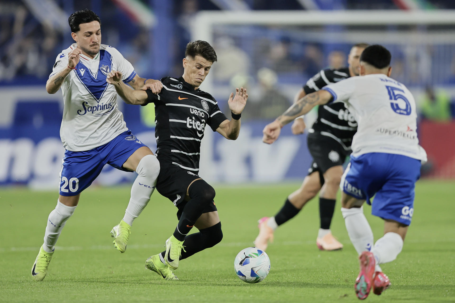 Francisco Pizzini (i) de Vélez disputa un balón con Javier Domínguez (2-i) de Olimpia en un partido de la fase de grupos de la Copa Libertadores. EFE/ Luciano González