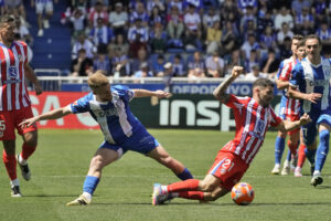 Javi Galán (d), del Atlético de Madrid, cae al suelo en una acción con Carlos Vicente, del Deportivo Alavés, durante el partido de LaLiga que enfrentó a sus equipos en el estadio de Mendízorrotza en Vitoria-Gasteiz.  EFE/ L. Rico